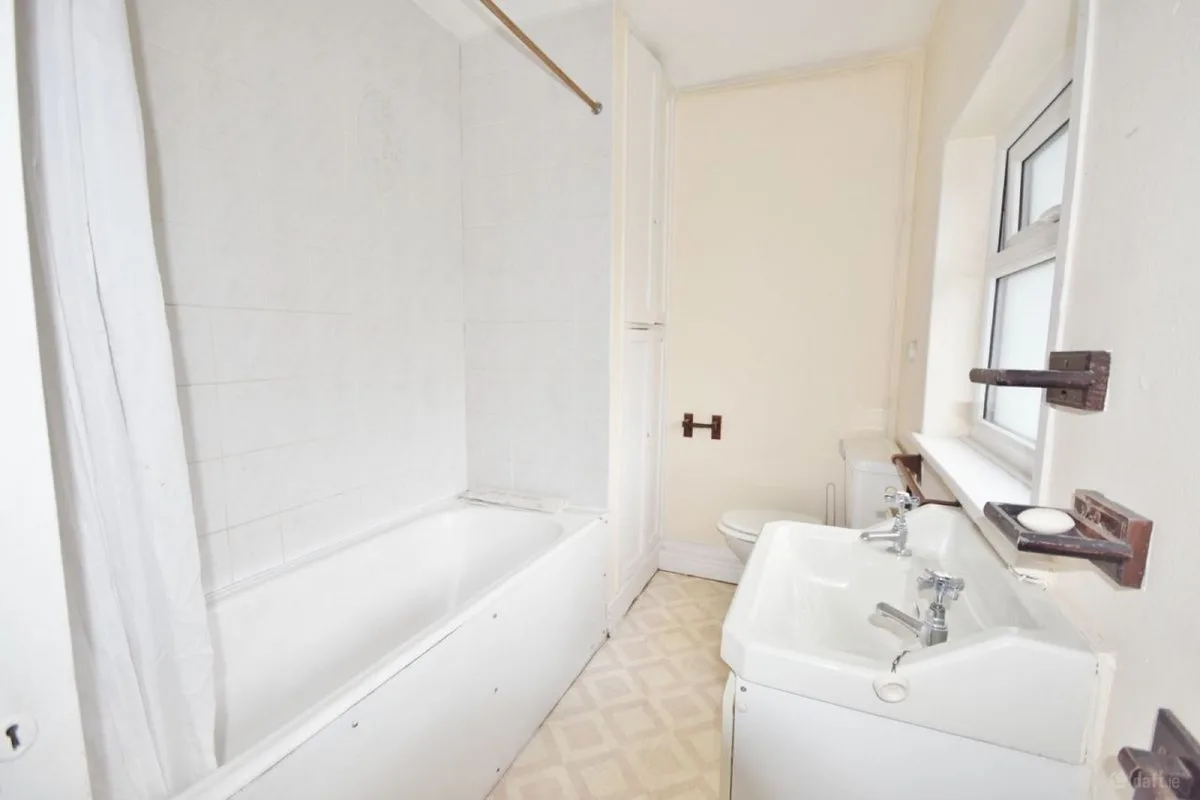 Bathroom before renovation, with white wall tiles and a bath